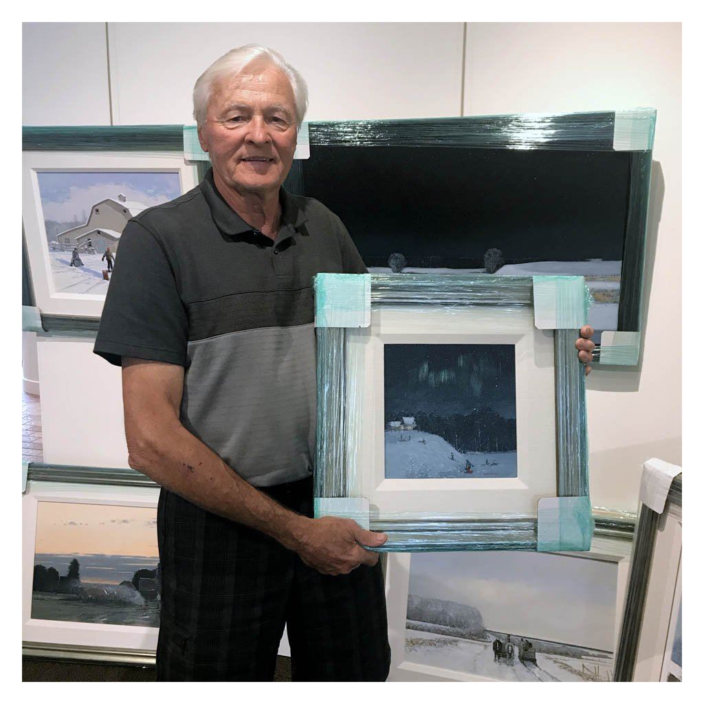 Peter Shostak Holding a painting at the West End Gallery