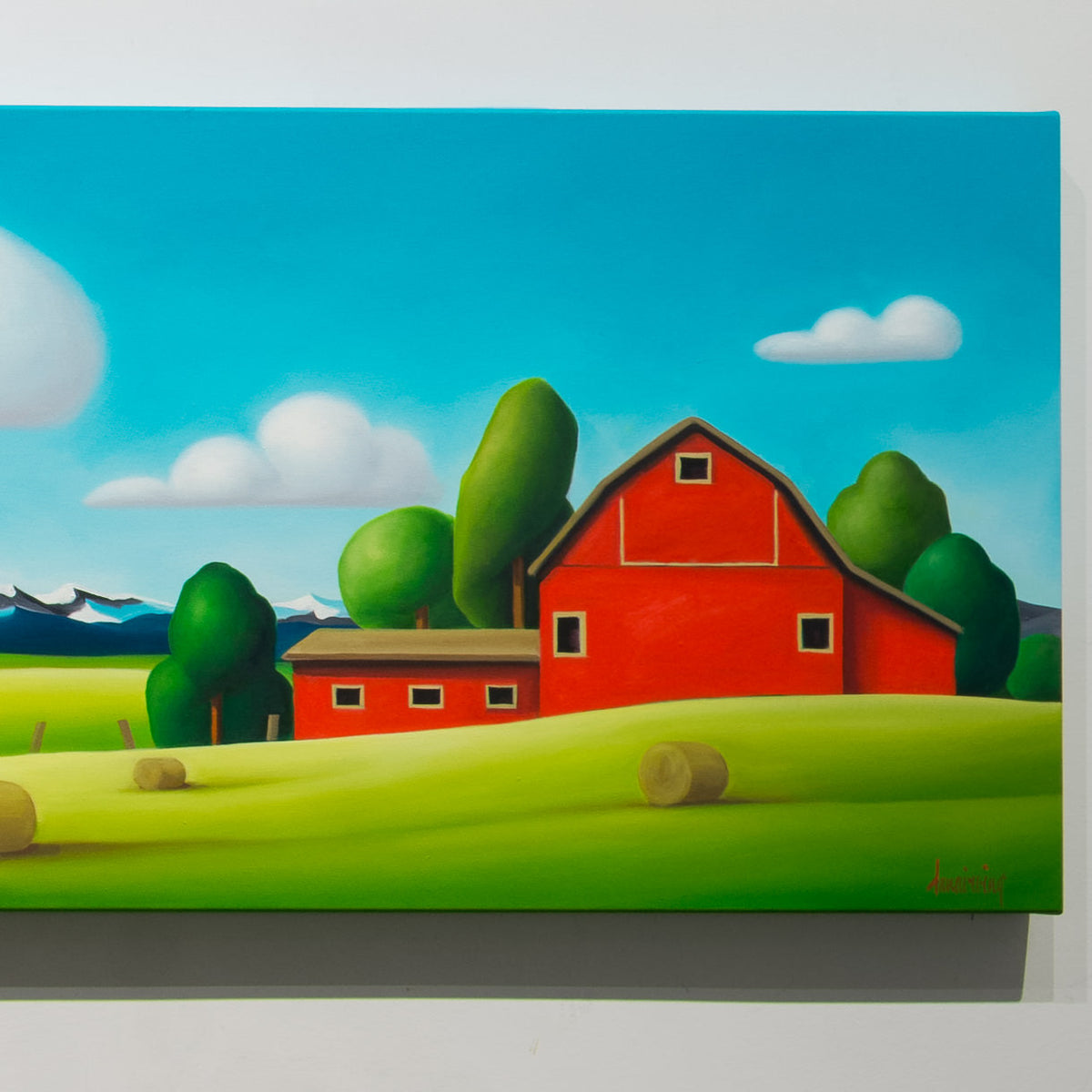 Detail of Dana Irving’s Red Barns: Cowboy Clouds showing a red barn, hay bales, green trees and distant mountains.
