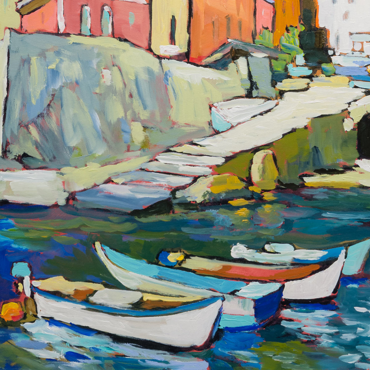 Detail of Riomaggiore Cinque Terre Italia showing small boats, harbour steps and saturated blue-green water beneath coral, orange and yellow buildings.